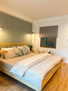 a large bed in a bedroom with a window at O2 Bangsaen in Ban Bang Saen (1)