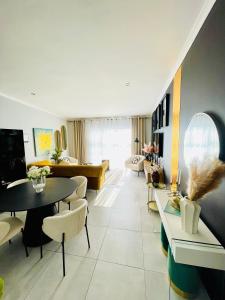a living room with a couch and tables and chairs at Cozy and Warm-Private Queen Bedroom with Private Bathroom & shared Kitchen& Lounge in Parklands