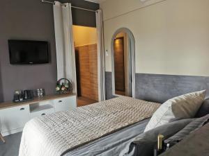 a bedroom with a bed and a flat screen tv at A Flor da Rosa in Vila Nova de Foz Coa