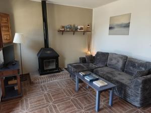 a living room with a couch and a wood stove at Alojamiento Rural El Balcón del Cielo in Trevélez