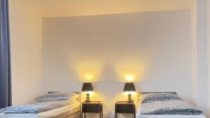 two beds in a room with two lamps at Domek 80m2 na wyłączność in Tczew