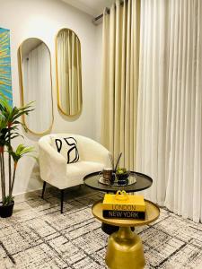 a living room with a chair and a table at Cozy and Warm-Private Queen Bedroom with Private Bathroom & shared Kitchen& Lounge in Parklands
