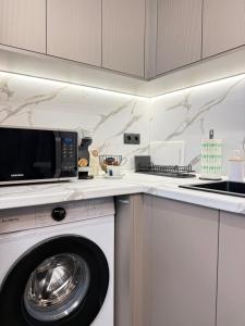 a kitchen with a washing machine and a microwave at Top Centre Apartment 5 mins to beach in Burgas +15 photos