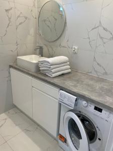 a bathroom with a washing machine and a mirror at Biebrzańska Przystań 7 in Goniadz