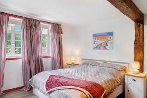 a bedroom with a bed and two windows at Zur Lupine in Bebra