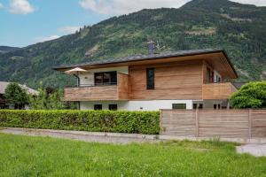 a house with a wooden fence in front of a mountain at Appartement Carmen in Uderns