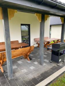 a group of benches on a patio with a grill at Biebrzańska Przystań 7 in Goniadz