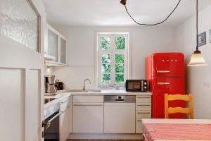 a kitchen with a red refrigerator and a sink at Zur Lupine in Bebra