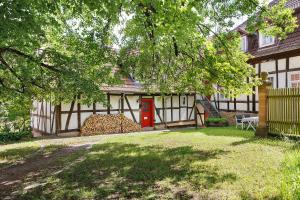 a house with a red door and a tree at Zur Lupine in Bebra