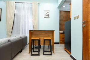 a dining room with a table and a couch at Akibo Residency Apartment in Mwanza