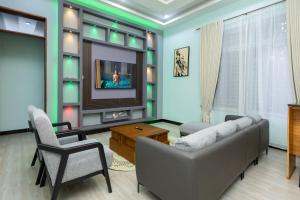 a living room with a couch and a tv at Akibo Residency Apartment in Mwanza +4 photos