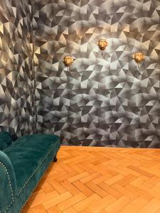 a green couch in a room with a wall at Exklusives und stilvoll eingerichtetes Apartment für Erwachsene in Bad Liebenwerda