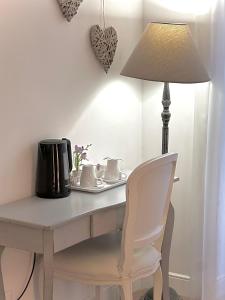 a white desk with a lamp and a white chair at Tre R Colosseo in Rome