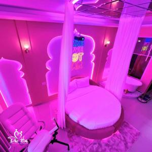 a pink room with a bed and two chairs at Đào Hoa Love Hotel Đà Lạt in Da Lat