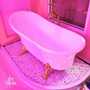 a pink bathroom with a tub filled with pink rocks at Đào Hoa Love Hotel Đà Lạt in Da Lat