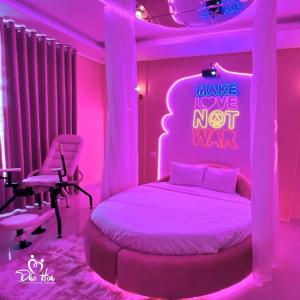 a bedroom with a bed with a pink neon sign at Đào Hoa Love Hotel Đà Lạt in Da Lat