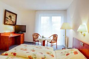 a hotel room with a bed and a table with chairs at Hotel Bonke in Nordhorn