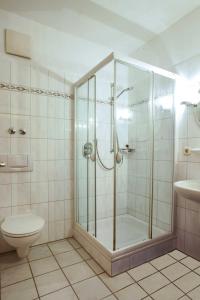 a bathroom with a shower and a toilet at Hotel Bonke in Nordhorn