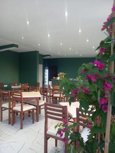 a dining room with tables and chairs and flowers at TE Shkodrant 1 in Baks-Rrjoll +23 photos