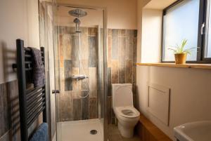 a bathroom with a toilet and a glass shower at Lynwood Barn - Barn Conversion in Midsomer Norton, Parking & Dog Friendly in Radstock +36 photos