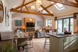 a living room with a kitchen and a living room with a table at Lynwood Barn - Barn Conversion in Midsomer Norton, Parking & Dog Friendly in Radstock