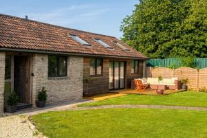 a house with a garden with a table and a patio at Lynwood Barn - Barn Conversion in Midsomer Norton, Parking & Dog Friendly in Radstock