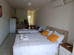 a bedroom with a large white bed with orange pillows at TE Shkodrant 1 in Baks-Rrjoll