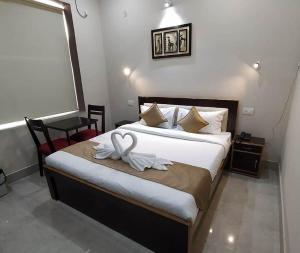 a bedroom with a bed with two swans on it at Zouk Homes in Rishīkesh +3 photos