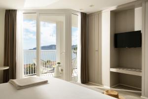 a bedroom with a bed and a view of a balcony at Hotel Helios Costa Tropical in Almuñécar