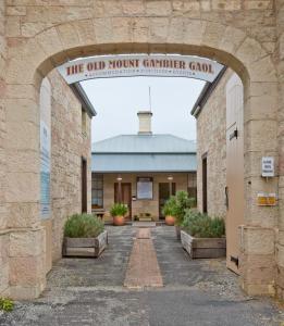 
a large stone building with a clock on it at The Old Mount Gambier Gaol in Mount Gambier
