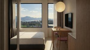 a hotel room with a bed and a table and a window at Stey Stavanger in Stavanger