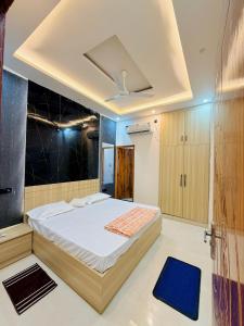 a bedroom with a large bed with a blue rug at Shri brijwasi palace in Vrindāvan