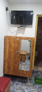 a wooden cabinet with a tv on a wall at Hotel green chinar & restaurant in Srinagar +17 photos