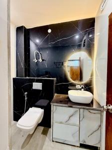 a bathroom with a sink and a toilet and a mirror at Shri brijwasi palace in Vrindāvan