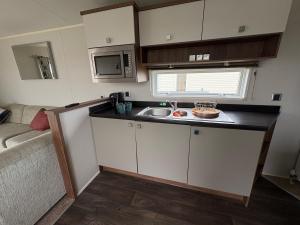a small kitchen with a sink and a microwave at Skyline in Lossiemouth