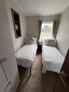 two beds in a small room with a window at Skyline in Lossiemouth