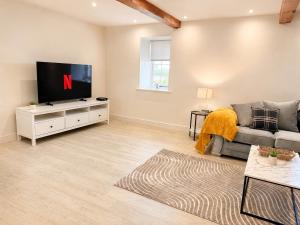 a living room with a tv and a couch at Yarwell Mill in Nassington