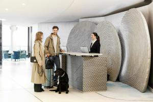 a group of people standing around a desk with a dog at The Westin Hamburg Elbphilharmonie in Hamburg +108 photos