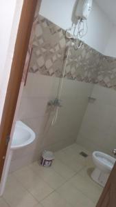 a bathroom with a shower and a sink and a toilet at Bhaavi Guest Inn in Jaffna