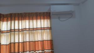 a room with a curtain and a air conditioner at Bhaavi Guest Inn in Jaffna