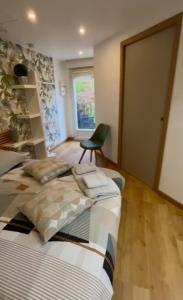 two beds in a room with a chair and a window at La maisonnette de chez Pascalou in Lège-Cap-Ferret +19 photos