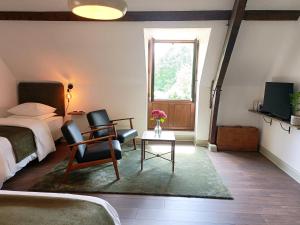 a bedroom with a bed and two chairs and a table at La Valaisienne in Val Couesnon