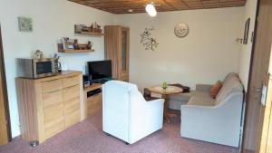 a living room with a couch and a tv at Ferienhaus am Wald in Augsburg