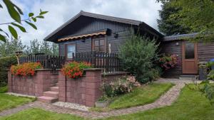 a small house with a fence and some flowers at Ferienhaus am Wald in Augsburg