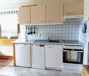 a kitchen with white appliances and a sink at Ferienhaus am Wald in Augsburg +13 photos