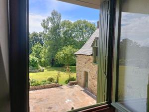 an open window with a view of a garden at La Valaisienne in Val Couesnon