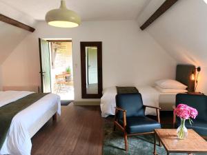 a bedroom with two beds and a table and chairs at La Valaisienne in Val Couesnon