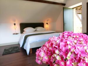 a bedroom with a bed and a bunch of flowers at La Valaisienne in Val Couesnon