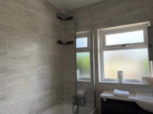 a bathroom with a shower and a sink at Llantarnam House by Tŷ SA in Cardiff