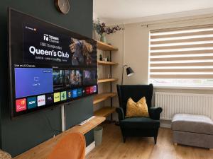 a living room with a large flat screen tv on a wall at Llantarnam House by Tŷ SA in Cardiff